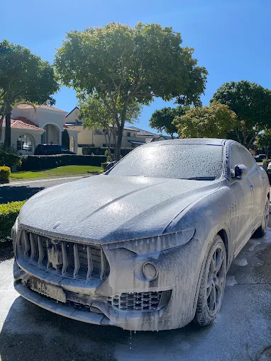 Maserati Levante covered in snow foam during a wash