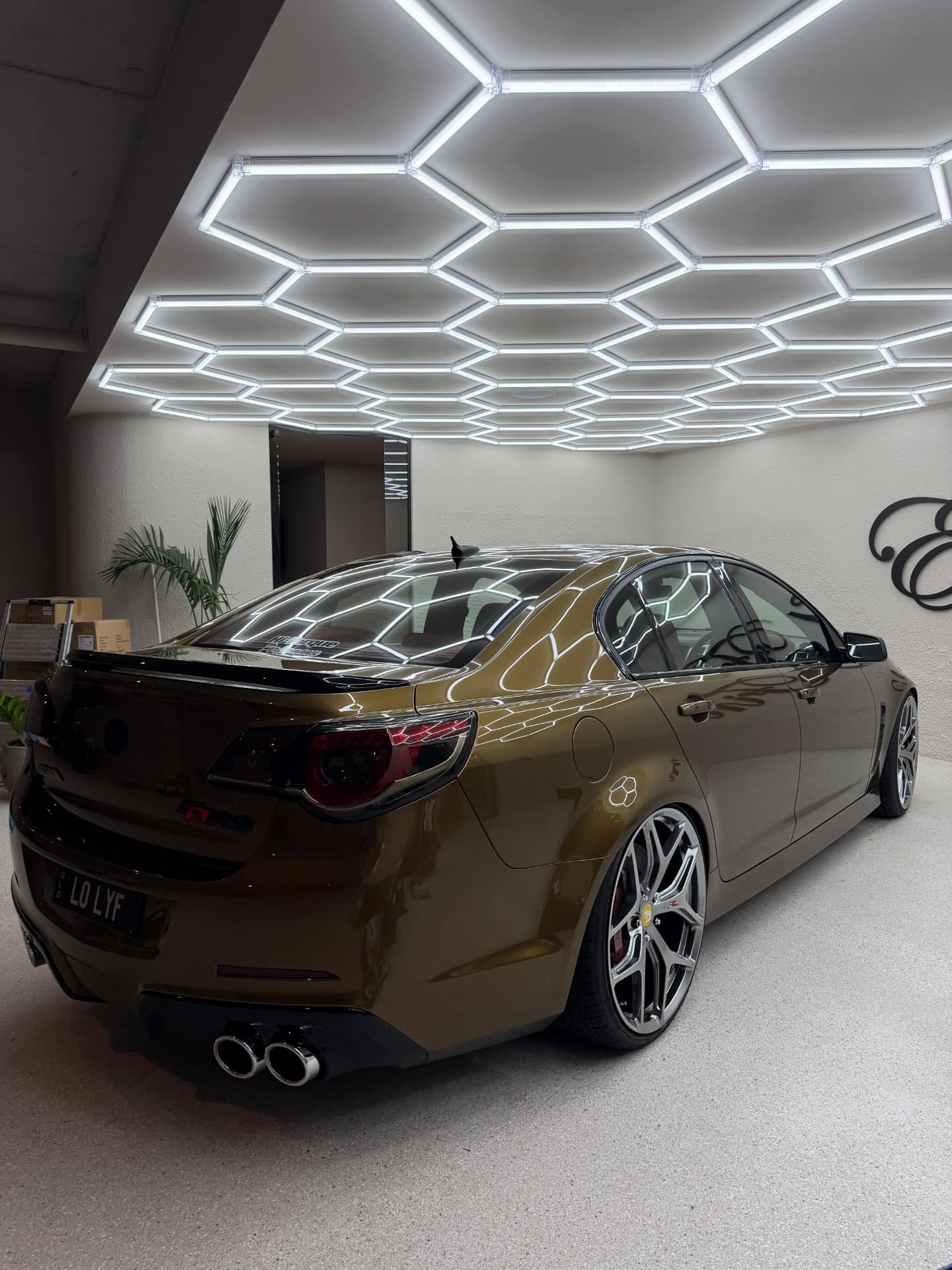 Holden Commodore with a flawless mirror finish reflecting a hexagon LED ceiling